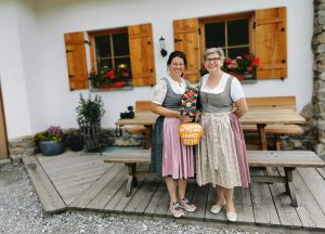 Zwei Frauen in Tracht vor Haibenalm mit Auszeichnung Almsommerhütte 2020 auf Salzburger Almwanderweg